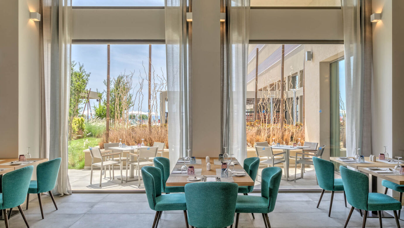 Tables prepared for lunch with garden view at Amada Colossos Resort restaurant