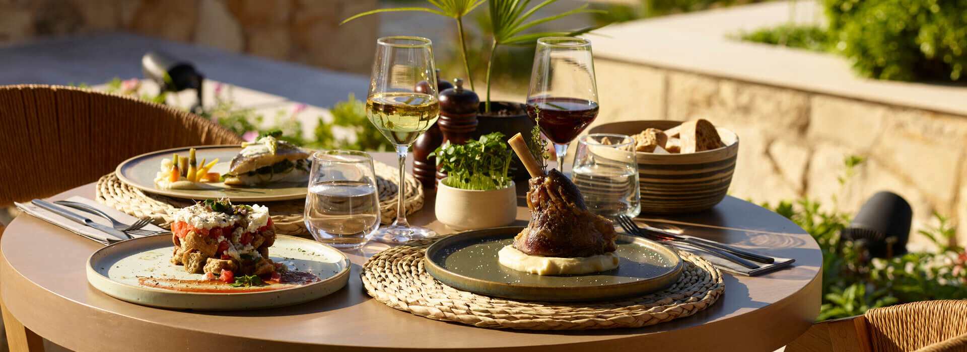 Elegant plated dishes paired with wine on a table at Asterion Suites Restaurant