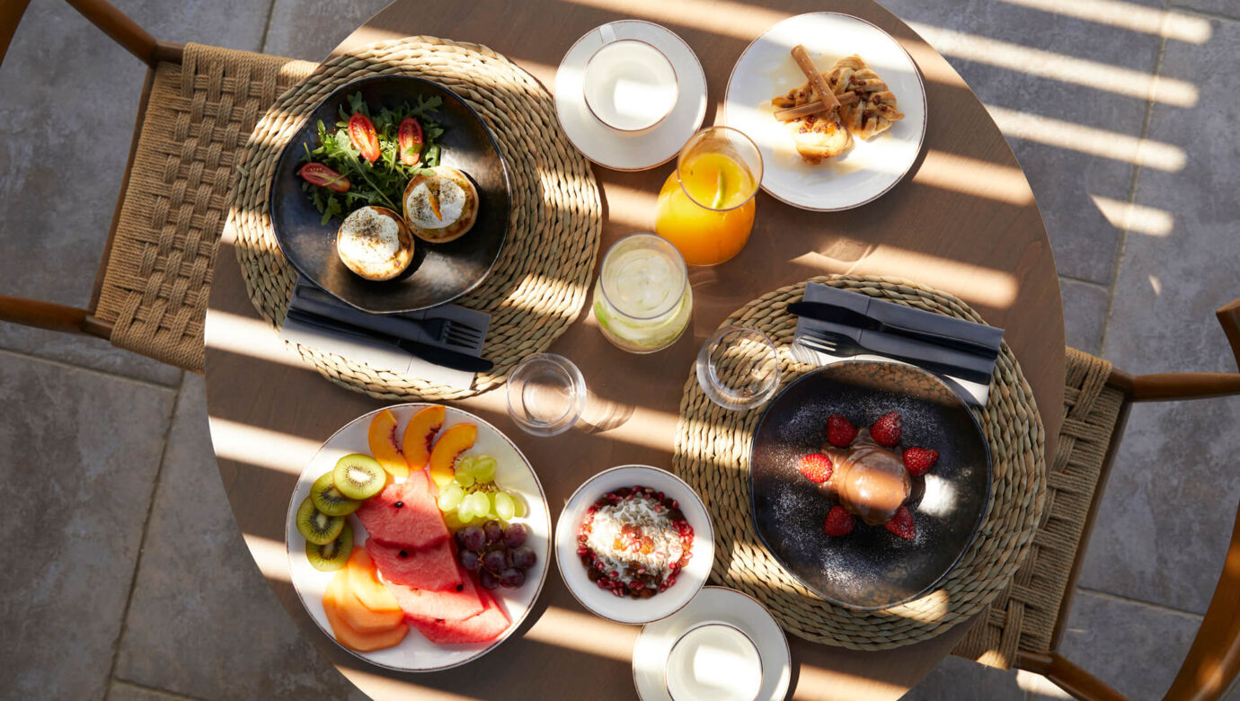 Table with breakfast dishes and drinks at Asterion Suites
