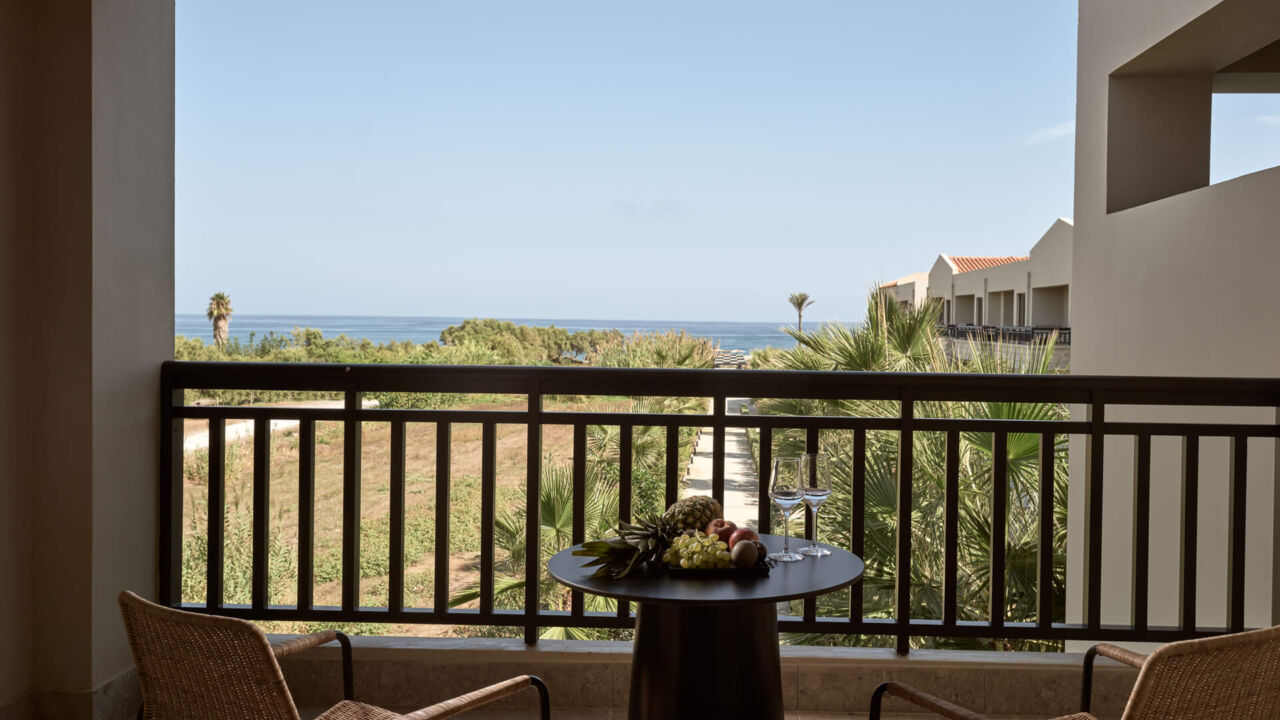 balcony with sea view and a table with fruits at Asterion Suites