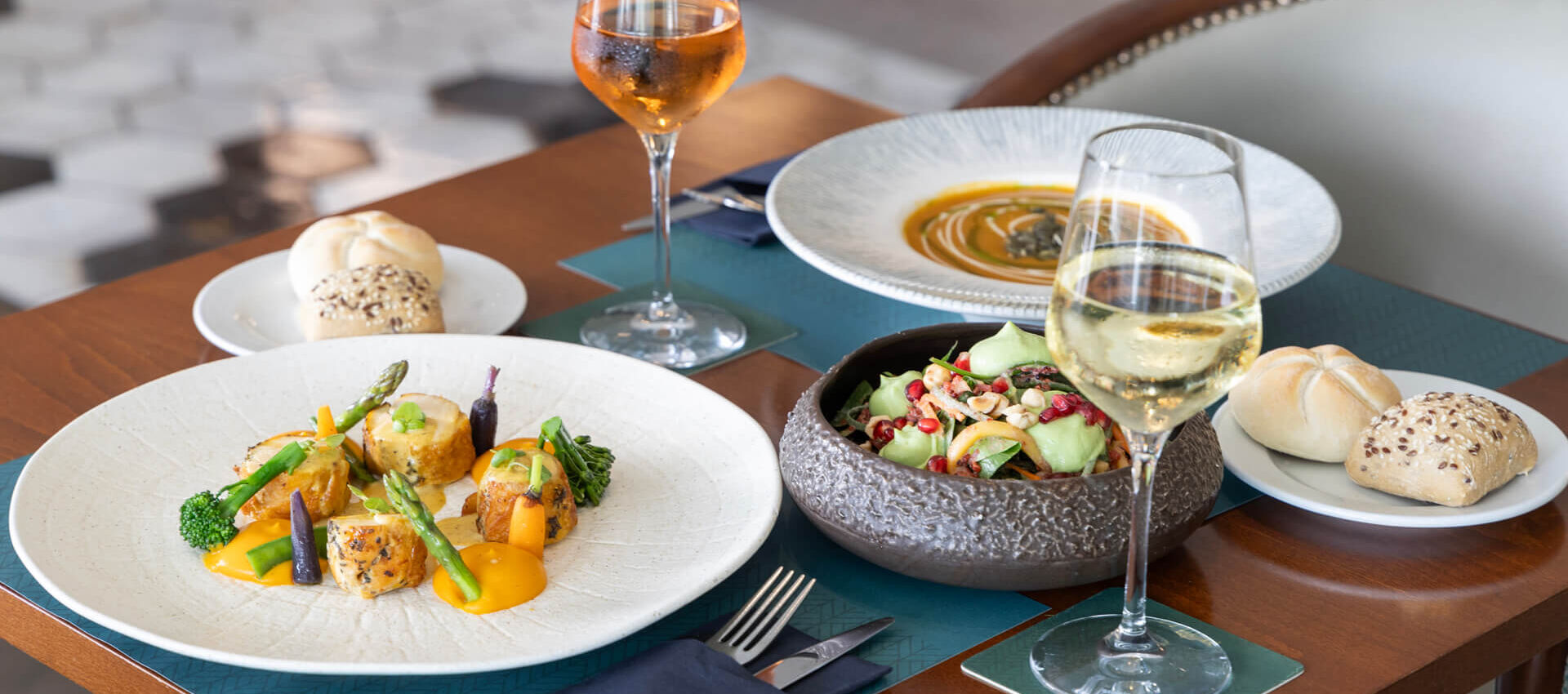 Table with salad and main dishes paired with wine at Hilton Nicosia restaurant