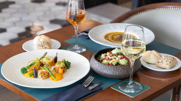 Table with salad and main dishes paired with wine at Hilton Nicosia restaurant