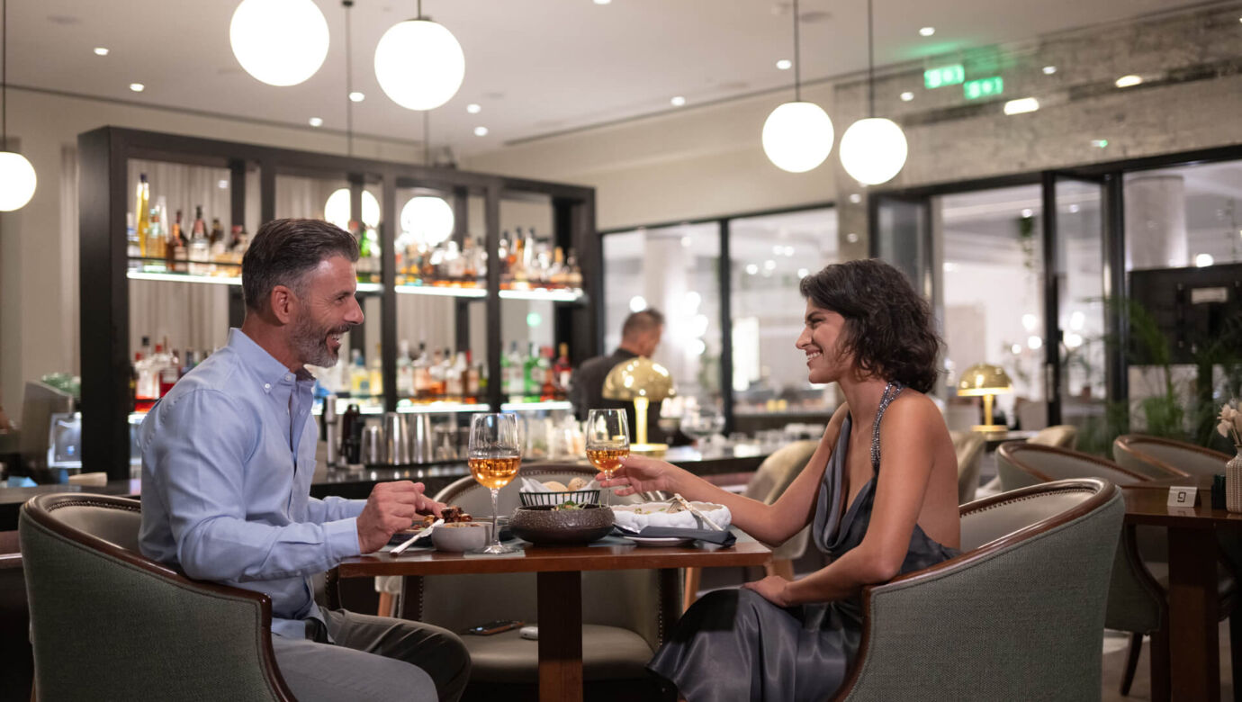 Couple drinking and eating at Hilton Nicosia Indoors bar