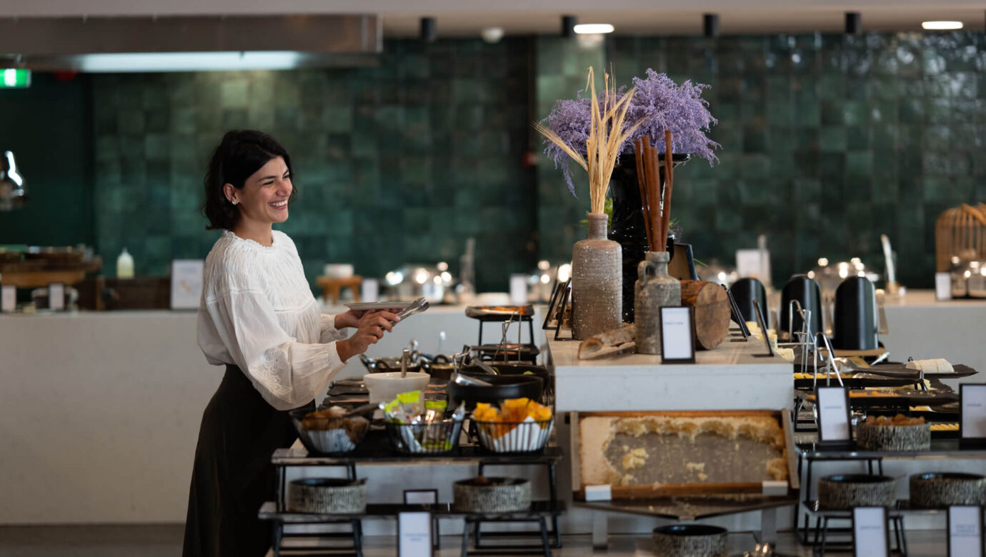 Woman getting food from buffet at Hilton Nicosia