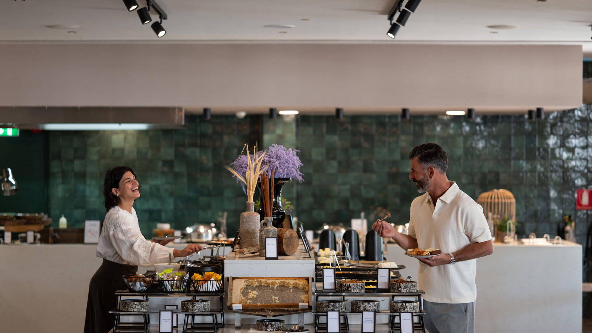 Couple getting food from buffet at Hilton Nicosia restaurant