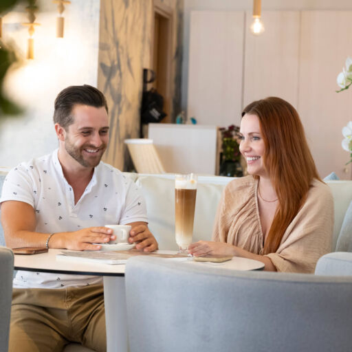 Couple enjoying drinks sitting at couch at Infinity Blu