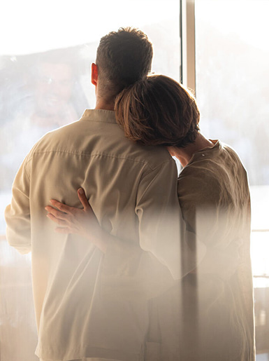 Couple embracing during a romantic anniversary getaway in a luxury hotel suite