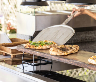 Chef serving fresh baked pizza at Kerkyra Blue restaurant