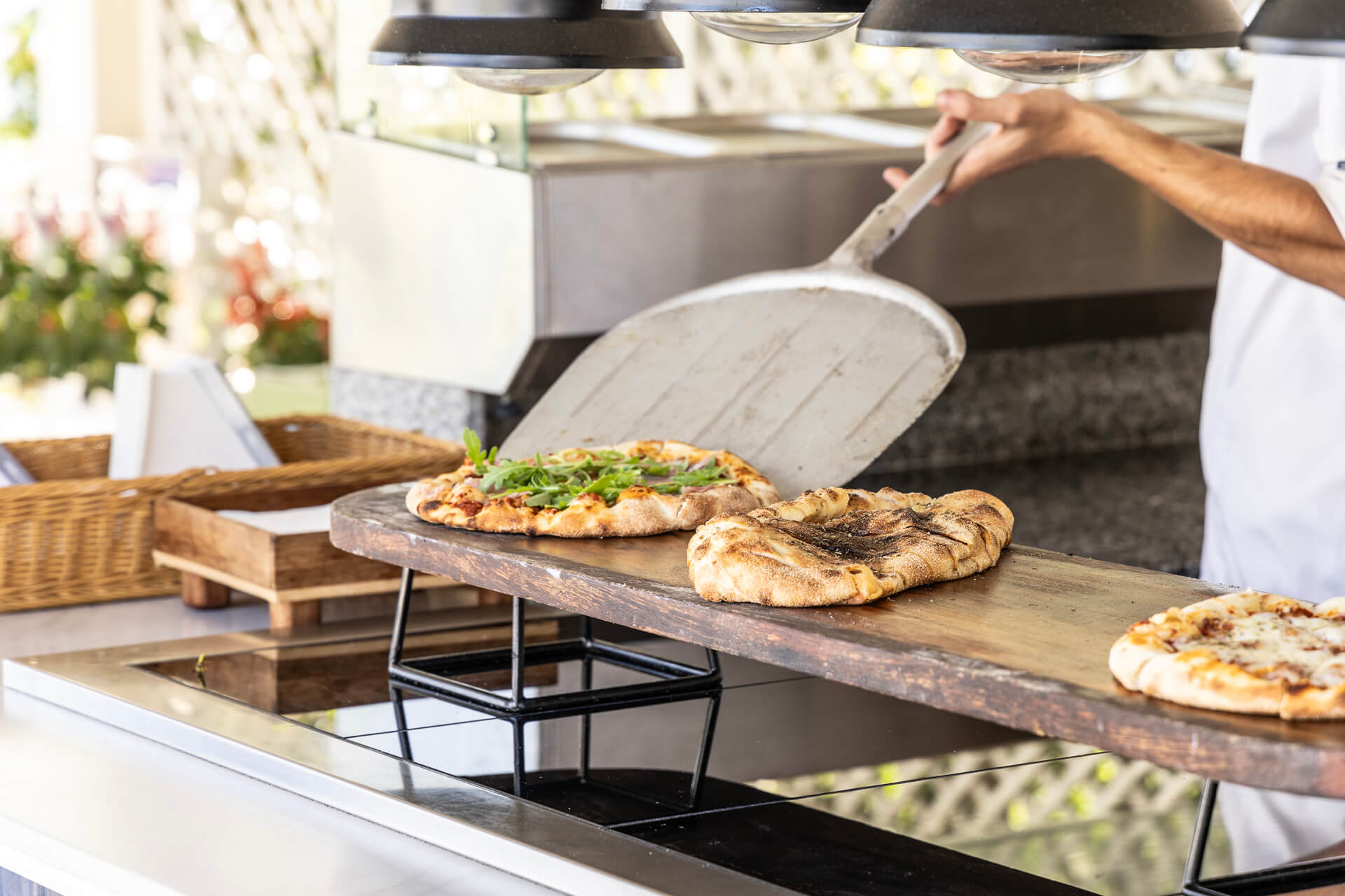 Chef serving fresh baked pizza at Kerkyra Blue restaurant
