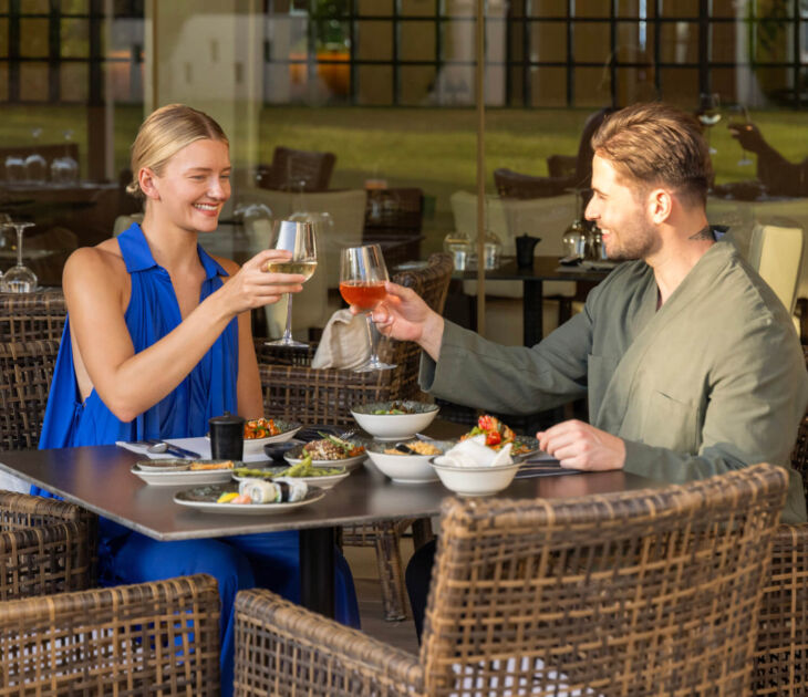 Couple eating and drinking wine at Kerkyra Blue Fiki restaurant