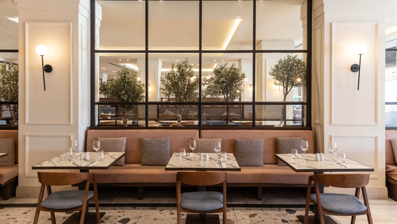 Indoor tables prepared for lunch at Kerkyra Blue Naida restaurant
