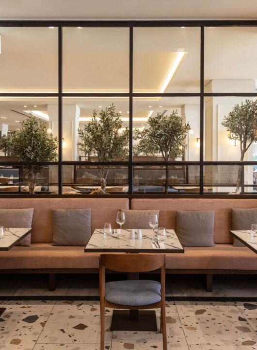 Indoor tables prepared for lunch at Kerkyra Blue Naida restaurant