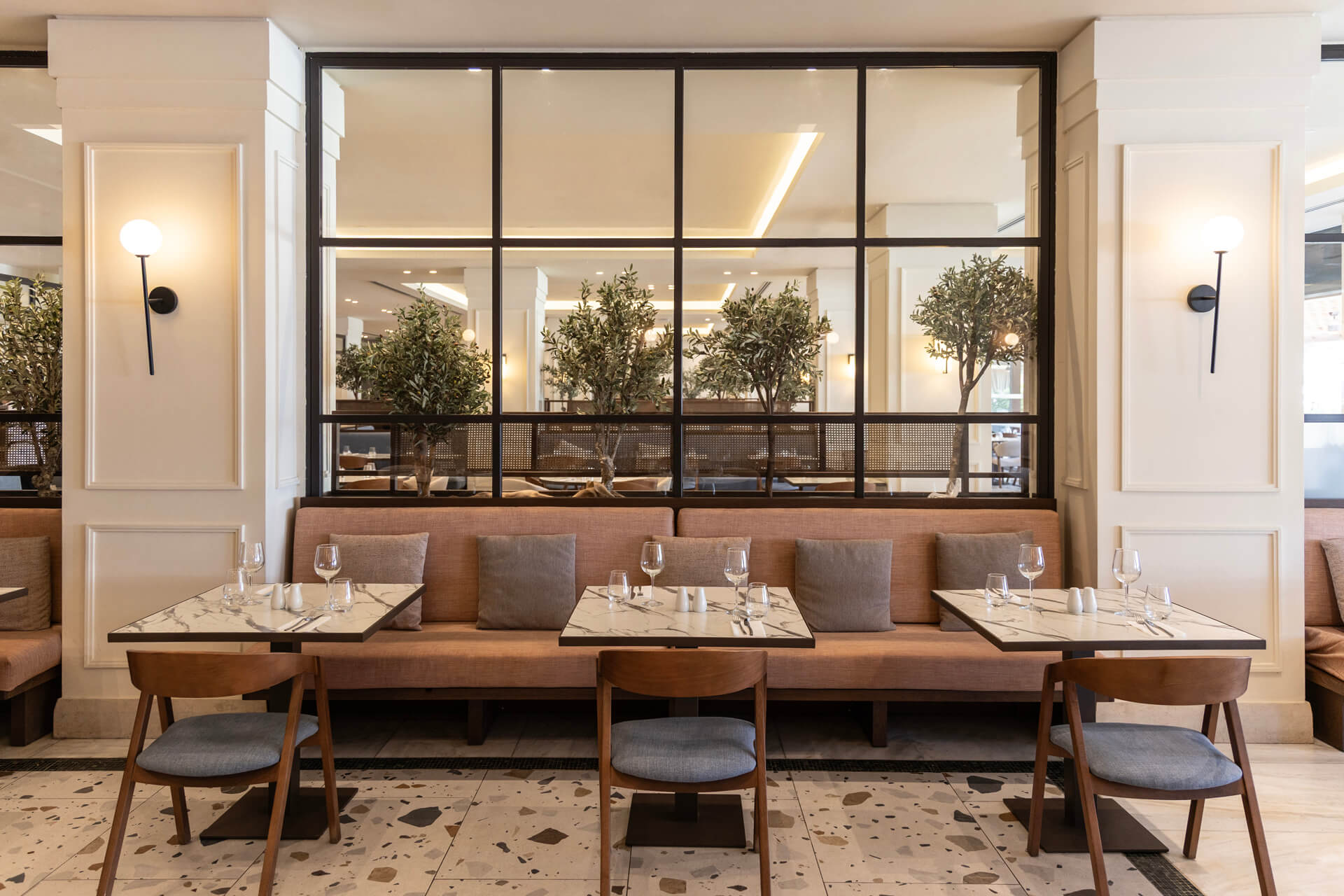 Indoor tables prepared for lunch at Kerkyra Blue Naida restaurant