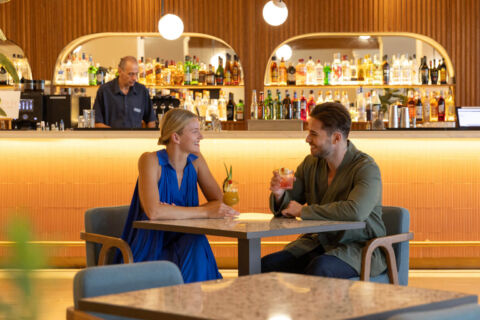 Couple drinking cocktails and smiling at Kerkyra Blue bar