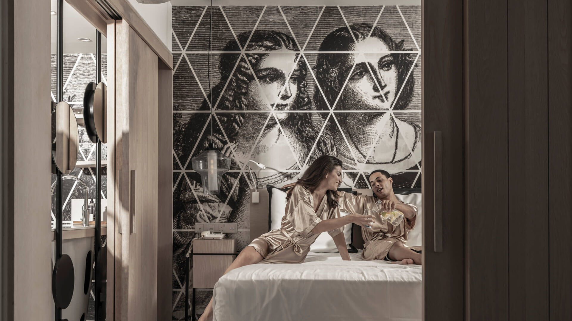 Couple relaxing on the bed at King Jason Protaras Suite