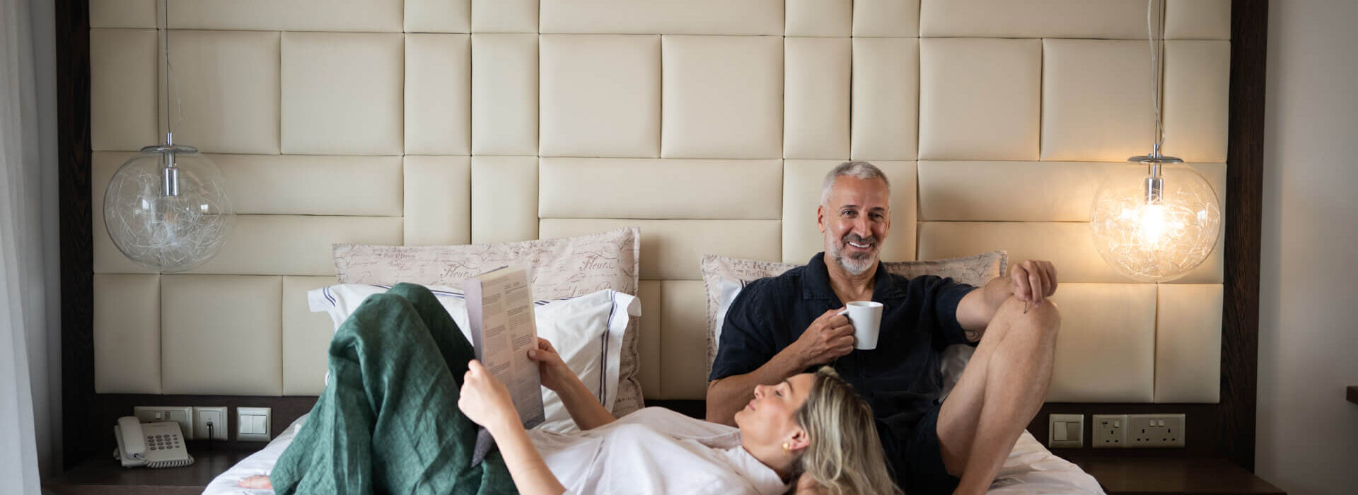 Couple relaxing on the bed at King Jason Paphos Room