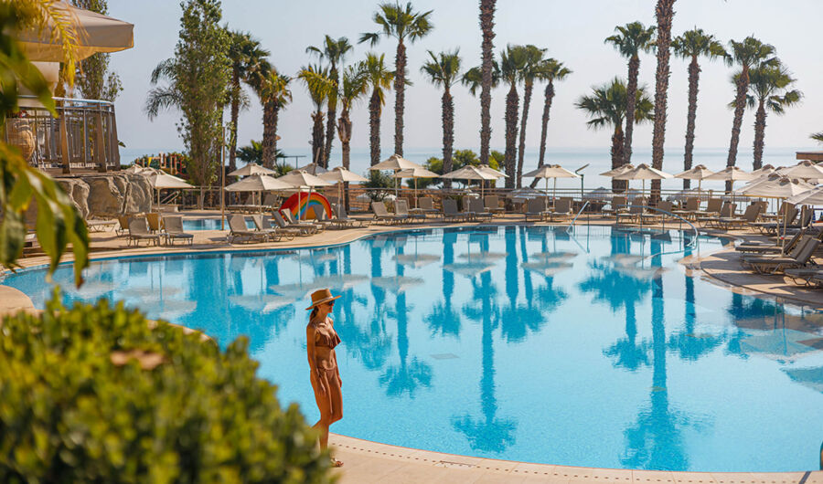 Woman walking near pool at Louis Althea Hotel