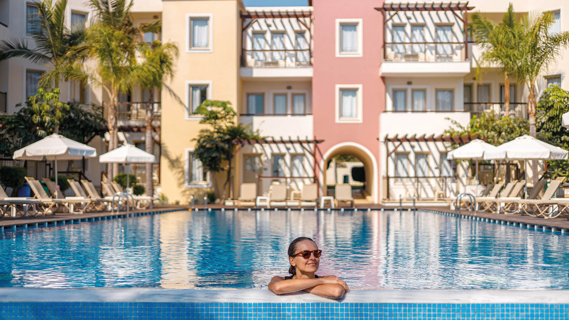 Woman swimming at the pool of Louis Althea Hotel