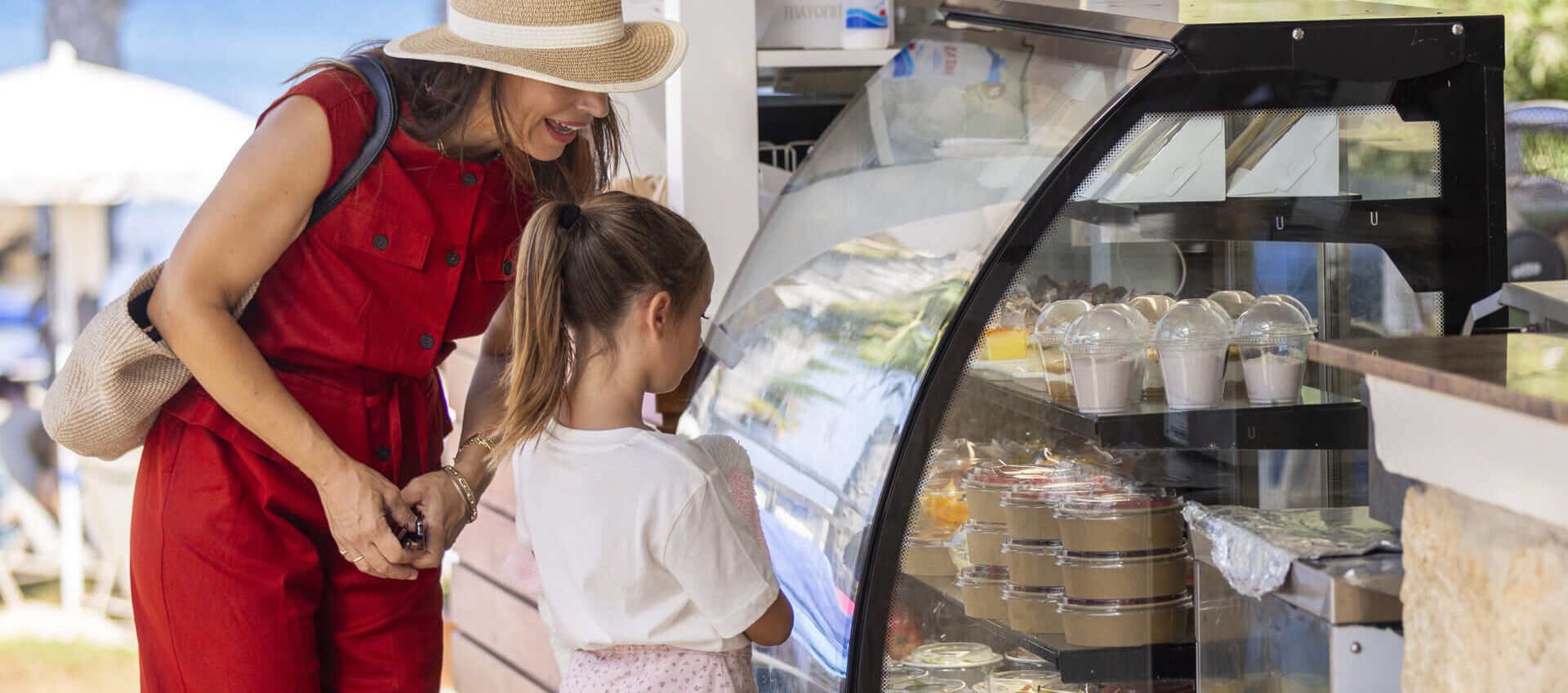 Woman and daughter getting food from althea pool bar