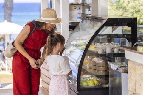 Woman and daughter getting food from althea pool bar
