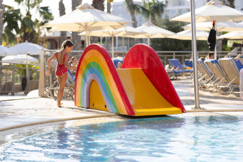 Kind playing with slide near the pool of Louis Althea
