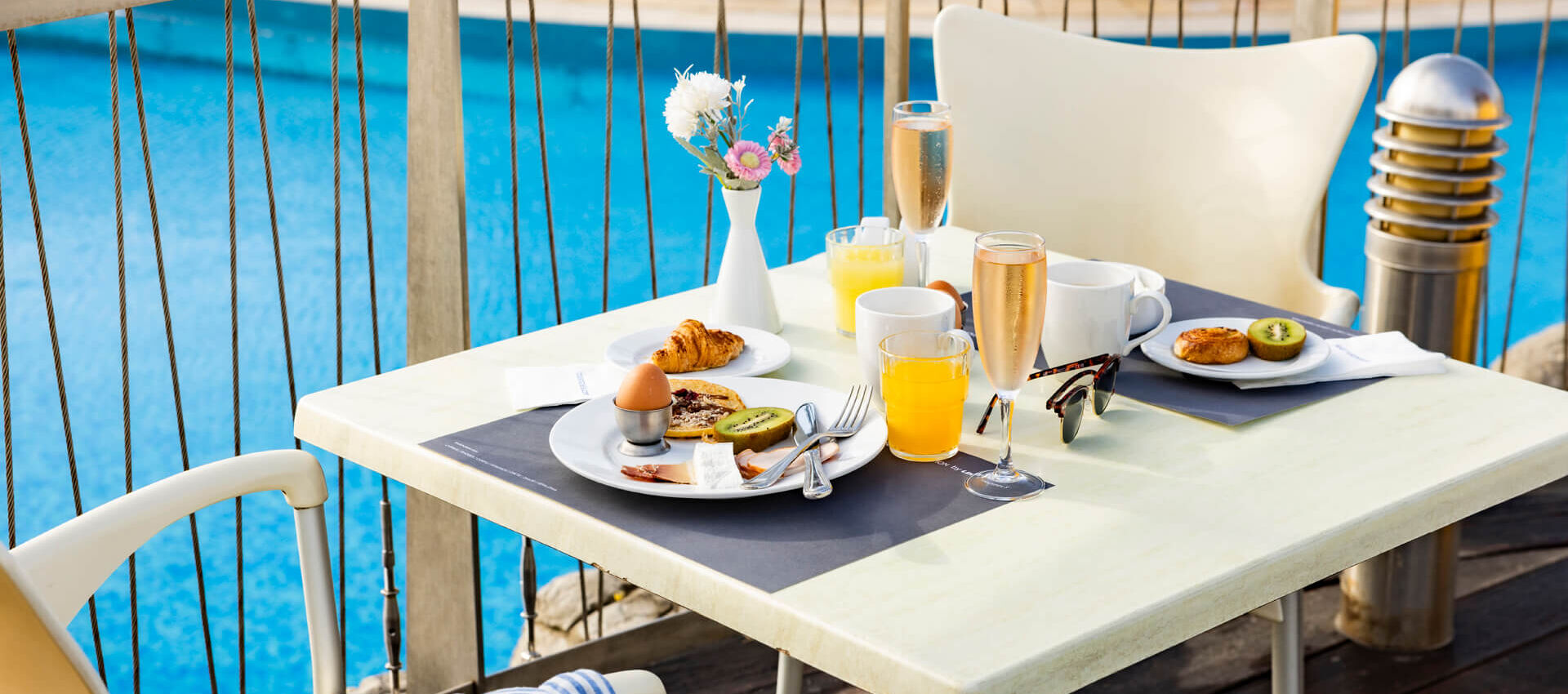 Table with breakfast poolside at Louis Althea restaurant