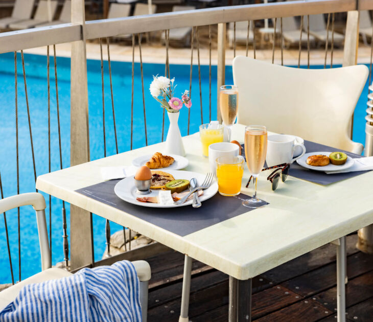 Table with breakfast poolside at Louis Althea restaurant