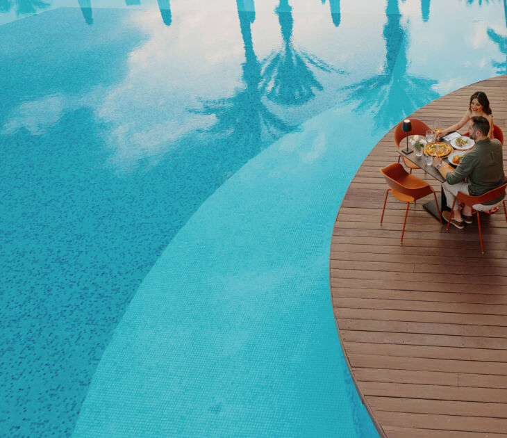 Couple eating near pool at Louis Ledra A mano restaurant