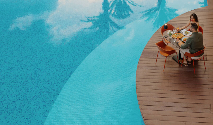 Couple eating near pool at Louis Ledra A mano restaurant