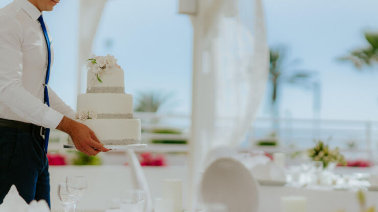 Waiter walking with wedding cake at Louis ledra Beach