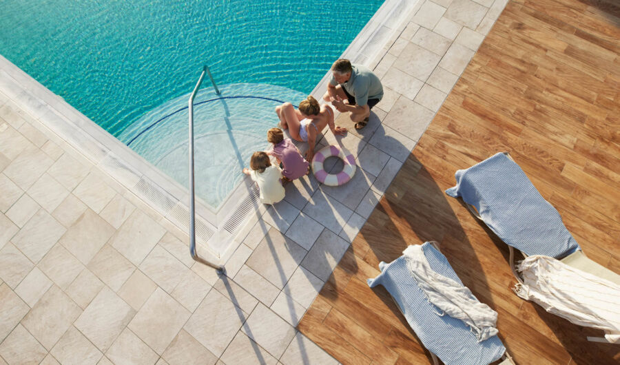 People sitting near the pool at Louis Nauiscaa Beach