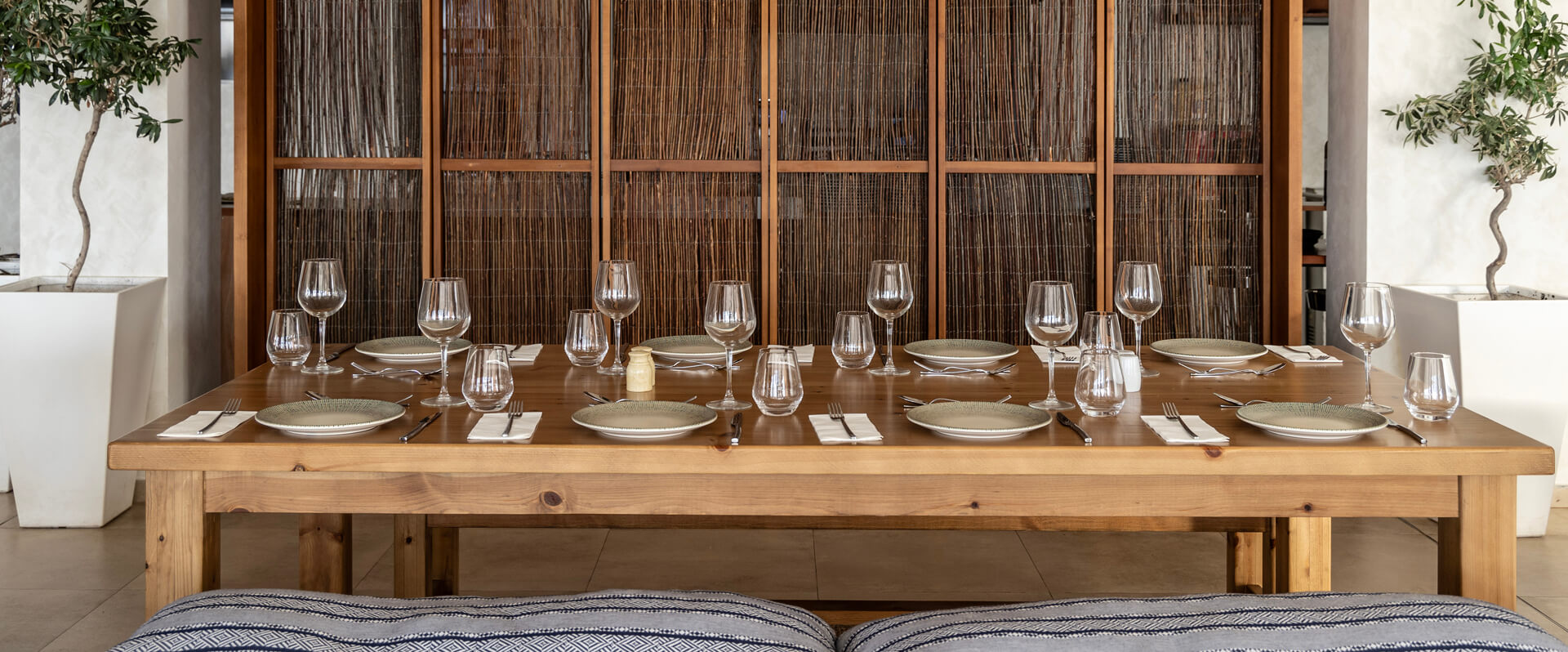Wooden dinner table prepared for dinner at Louis Nausicaa Taverna restaurant