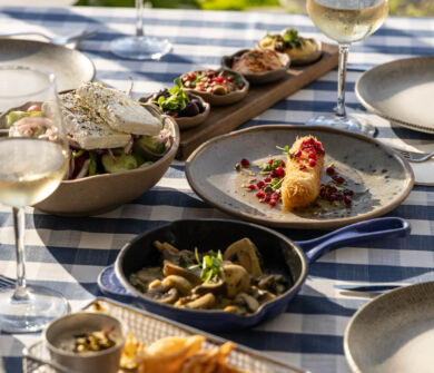 Table full with appetizers and wine at Louis Nausicaa Taverna restaurant