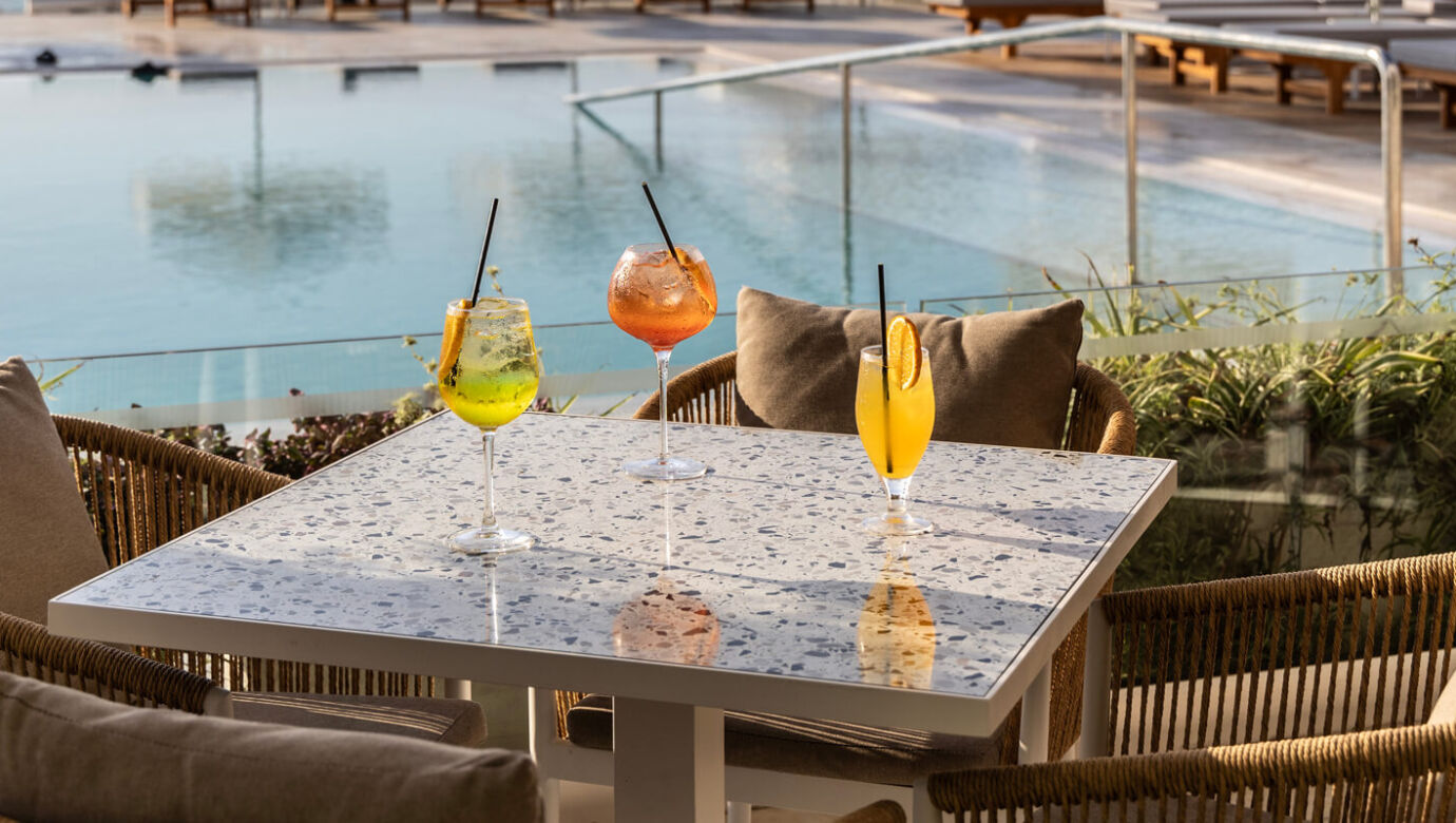 Drinks at a table at Louis Nausicaa Thea bar with pool view