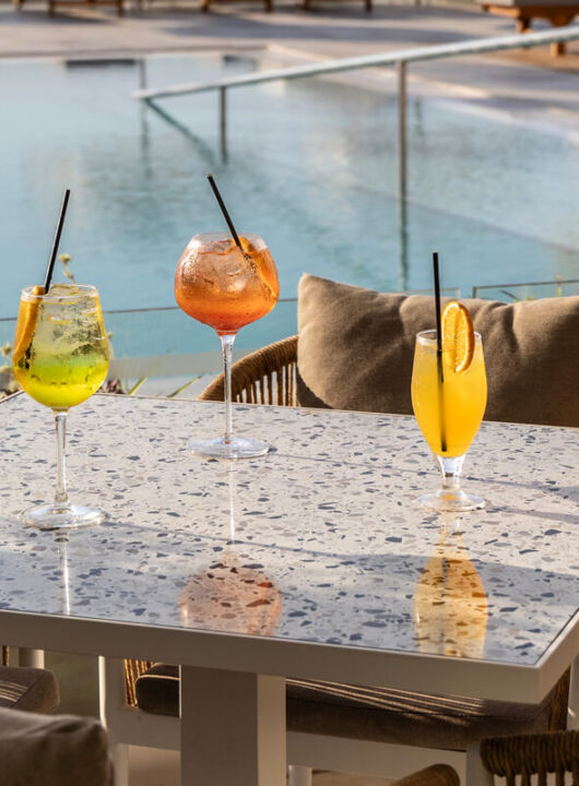 Drinks at a table at Louis Nausicaa Thea bar with pool view