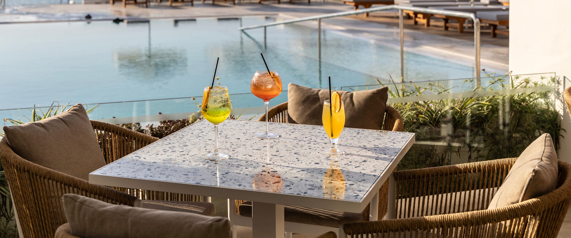 Drinks at a table at Louis Nausicaa Thea bar with pool view