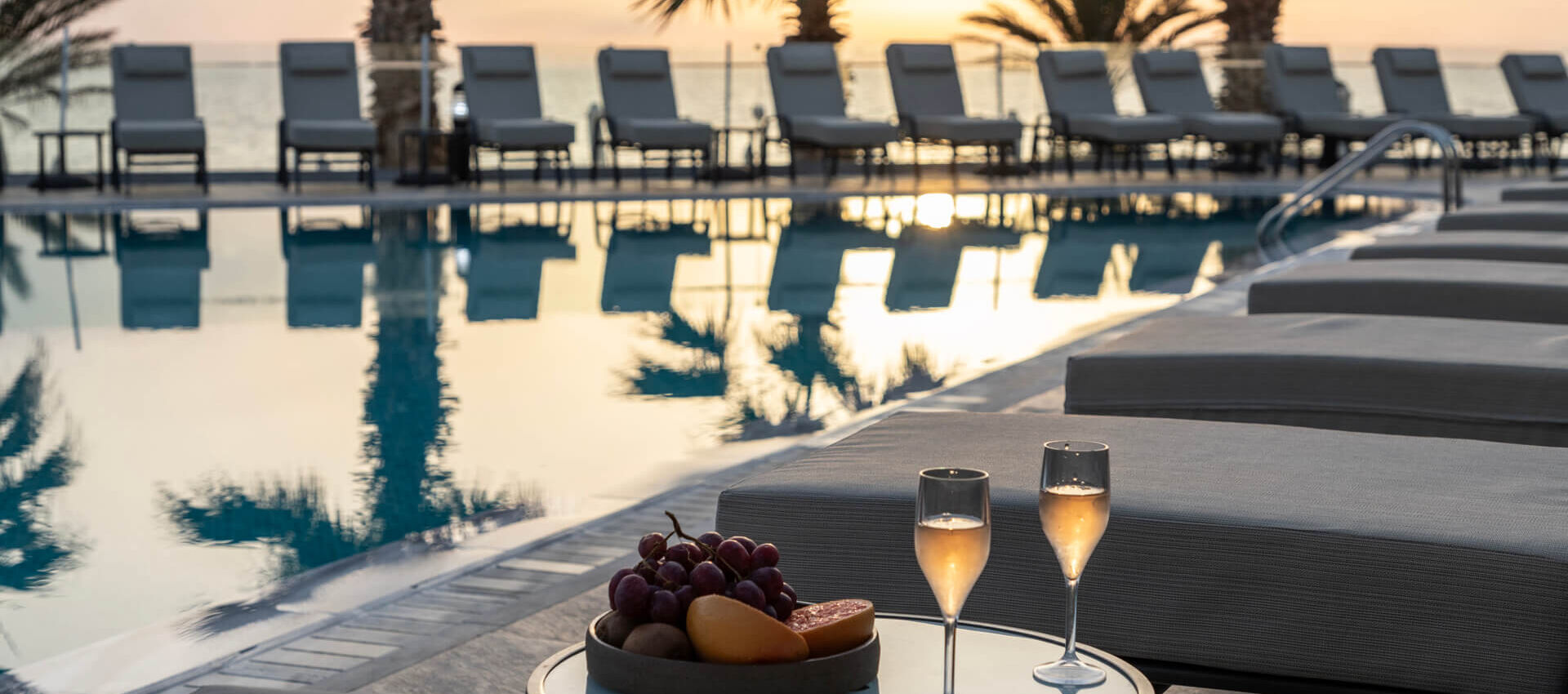 Sunbeds with sidetable with snack and wine at Louis Paphos Breeze