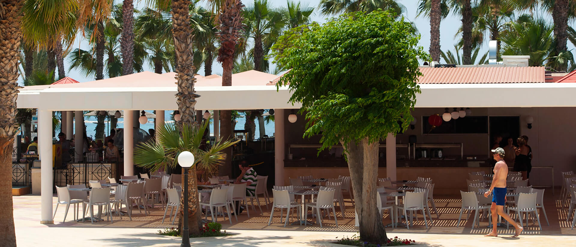 Louis Phaethon Helios bar outdoor tables and a man in the front walking