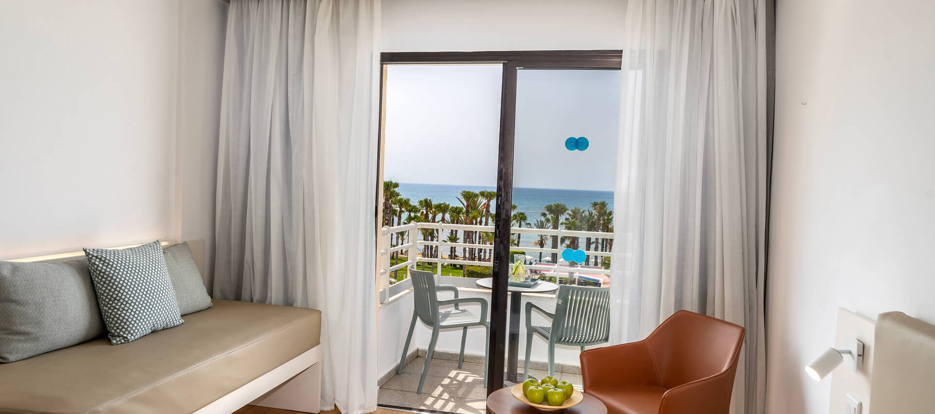 Louis Phaethon twin room couch and balcony with sea view