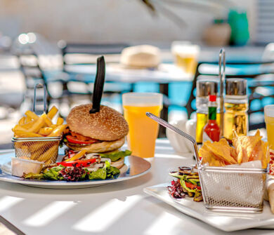 Table with burger and burrito poolside at Louis Althea restaurant