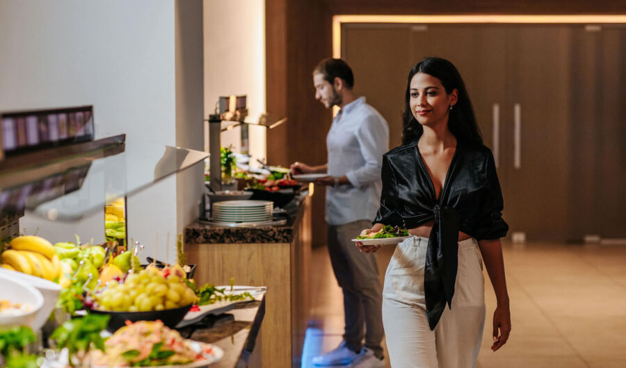 Woman getting food at Sofianna Resort restaurant buffet