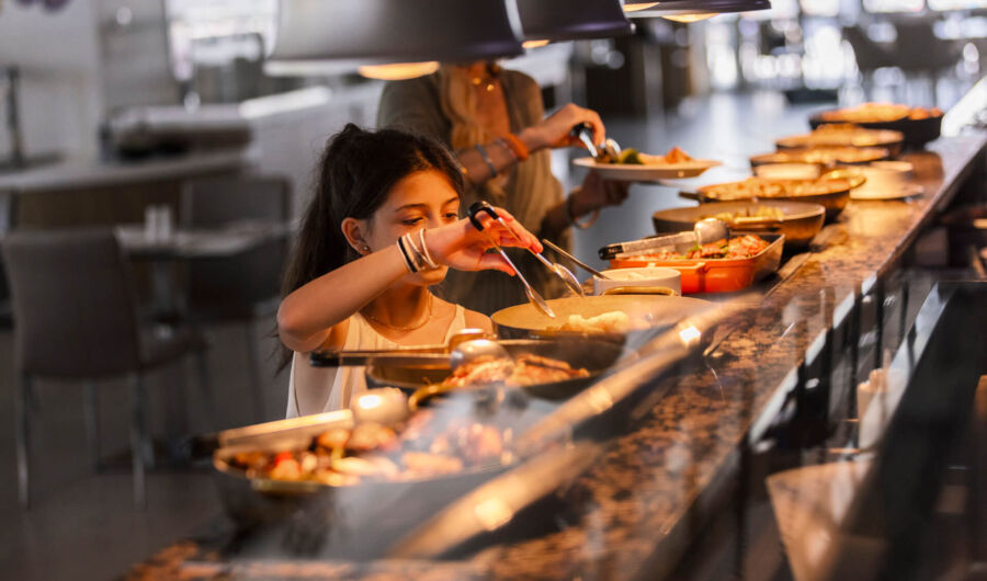Child getting food from Sofianna Resort restaurant buffet