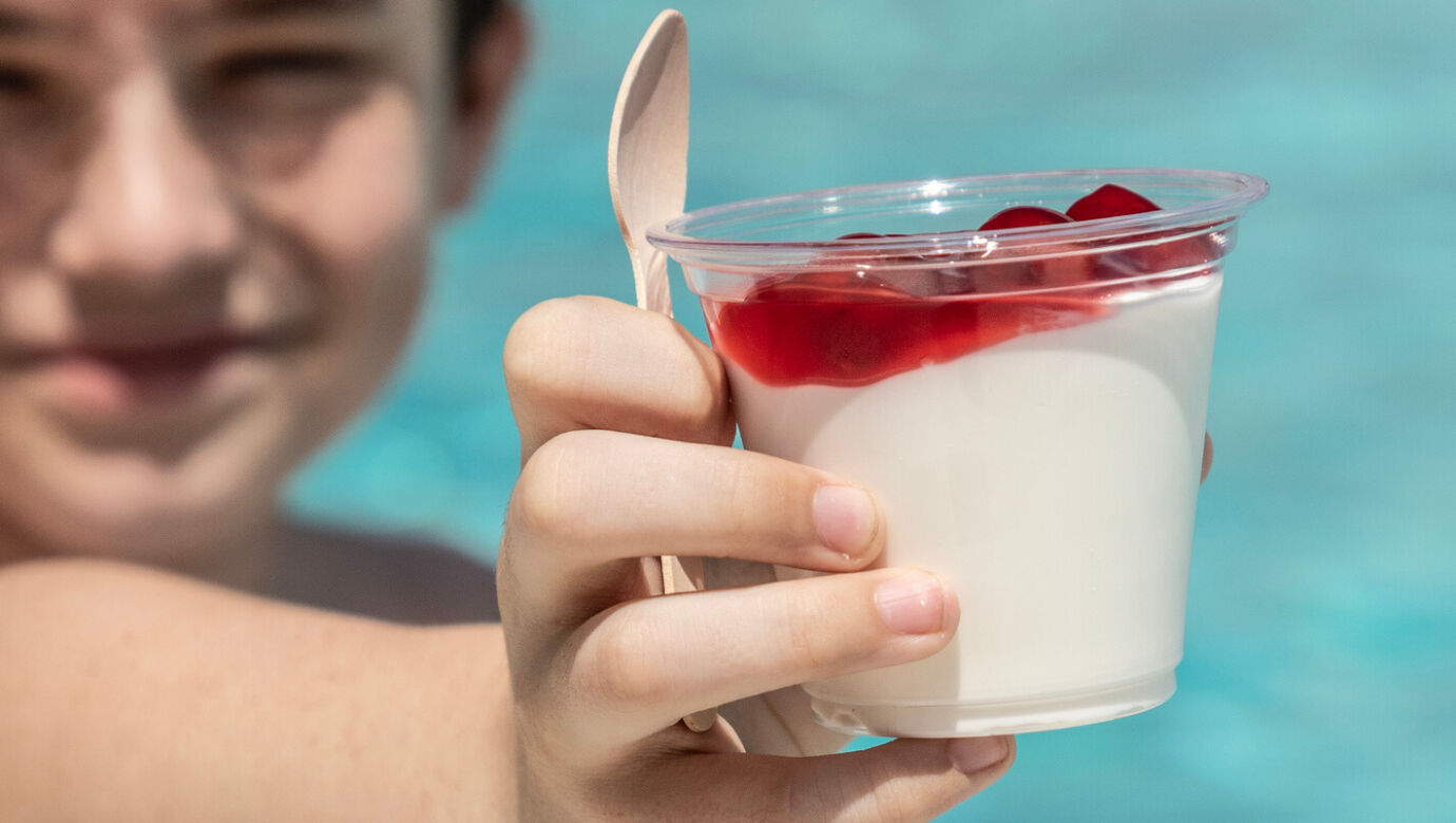 Kid presenting a desert in front of a pool at St.Elias