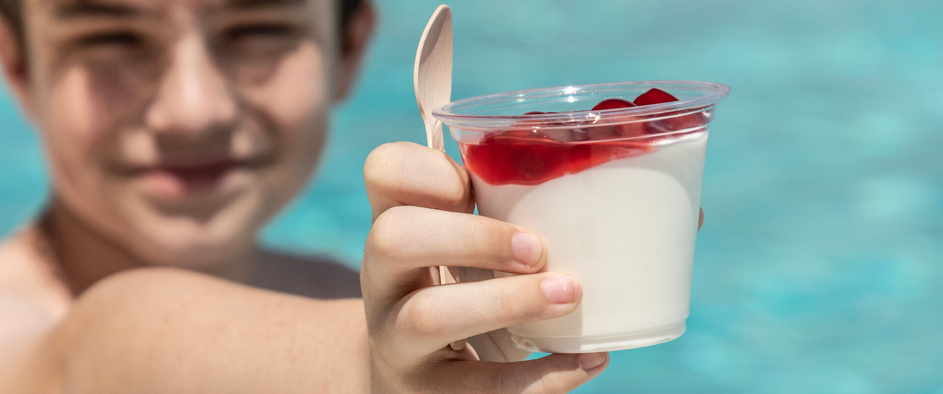 Kid presenting a desert in front of a pool at St.Elias