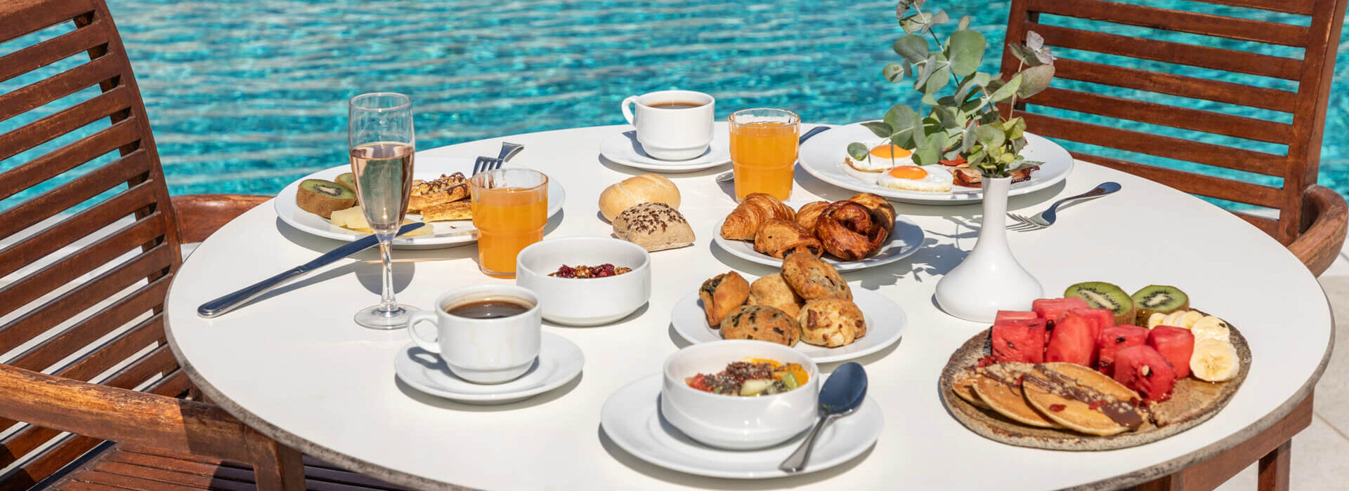 Table Full of breakfast dishes pool side at Louis St. Elias