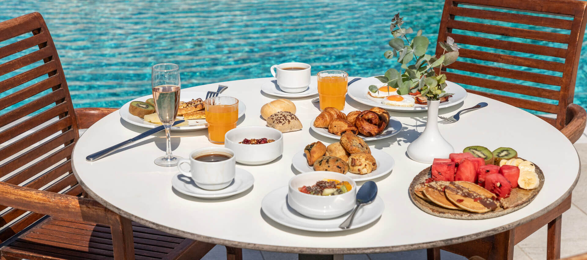 Table Full of breakfast dishes pool side at Louis St. Elias