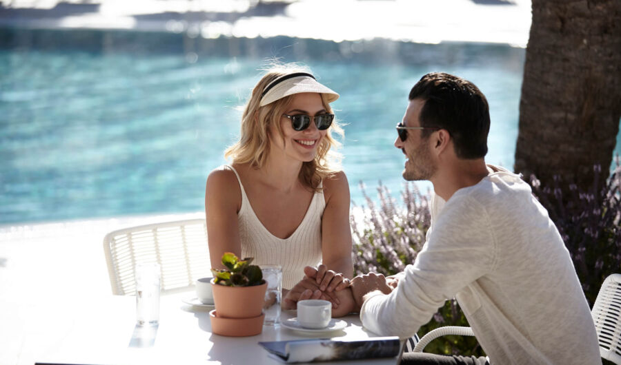 Couple eating and drinking near the pool of Louis St.Elias