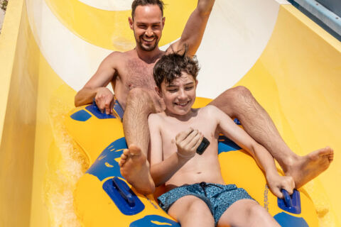 Father and child going down a slide