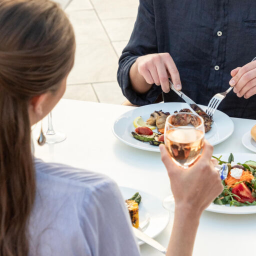 Man eating and Woman drinking wine at Louis St. Elias restaurant