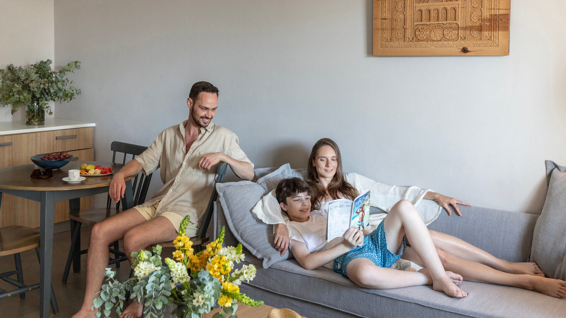 Family relaxing in couch and table inside suite at Louis St. Elias